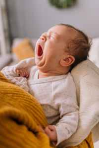 Infant crying lying in a bed