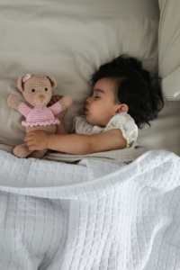 Infant sleeps with a cuddly toy in his hand