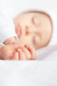 cute newborn side sleeping in the bed