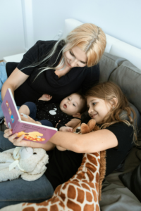 The mother reads stories to the infants and children