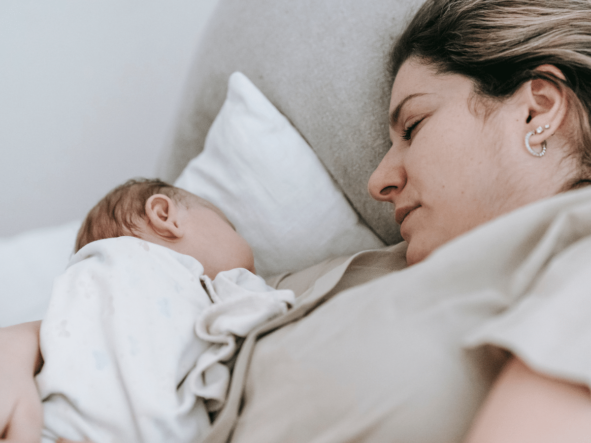 Mother holds baby in her arms while he sleeps